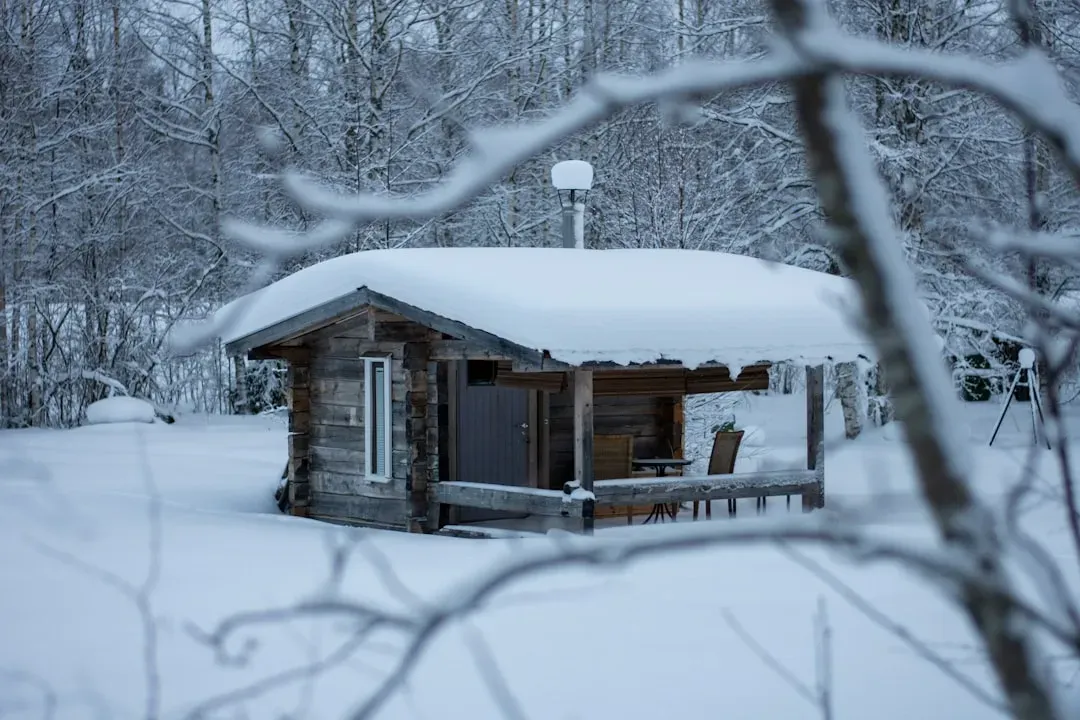 Traditional Finnish wooden sauna glowing warmly in snowy winter landscape, representing sauna research and cultural heritage