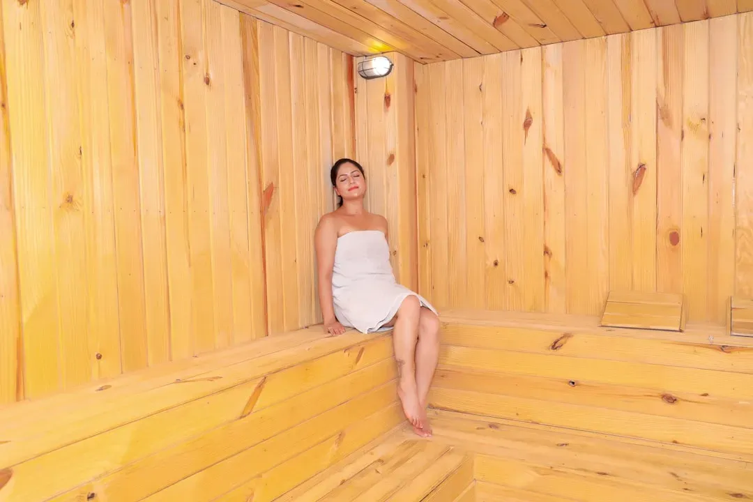 Older adult enjoying safe heat therapy in a well-maintained sauna facility, demonstrating proper posture and wellness practic