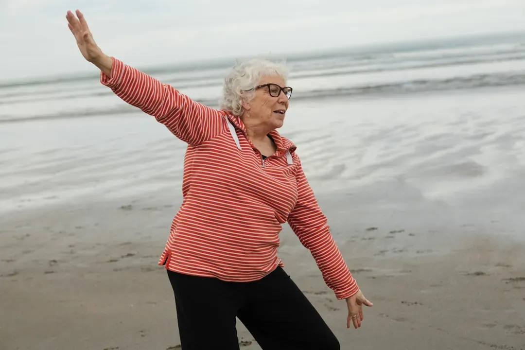 Senior adult stretching outdoors in natural light, demonstrating flexibility and wellness benefits from red light sauna thera
