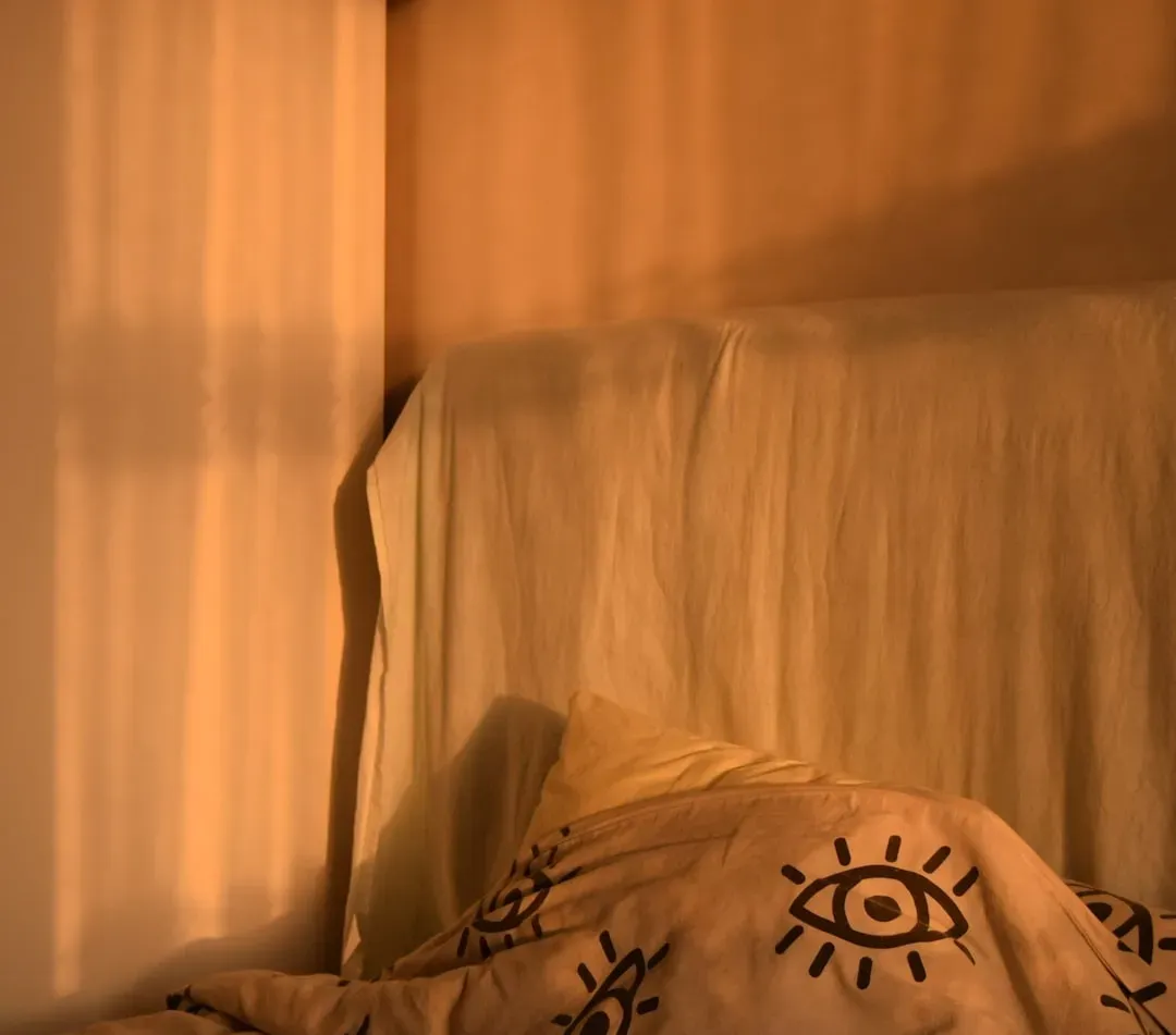 Person relaxing in dimly lit bedroom after sauna session, preparing for quality sleep with calming pre-sleep routine